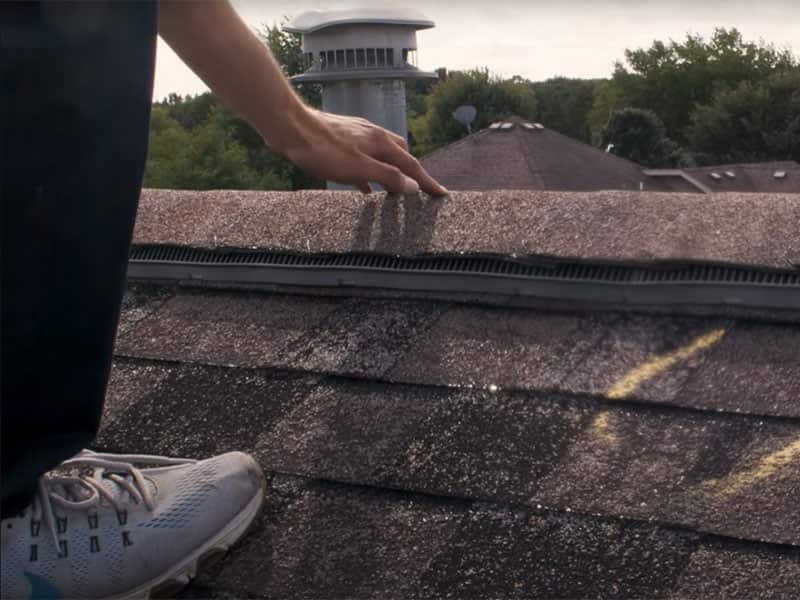 Closeup of a Martindale Pinnacle Construction worker inspecting a roof in order to access damage or areas of concern in order to start the insurance claim process